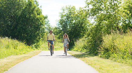 Image showing happy young couple riding bicycles in summer