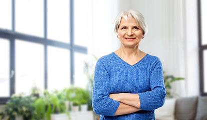 Image showing smiling senior woman in blue sweater at home