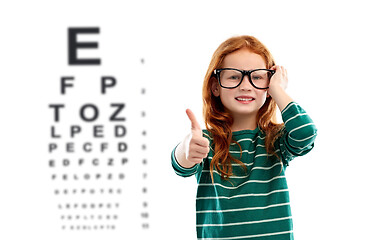 Image showing red haired girl in glasses over eye test chart