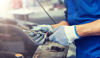 Image showing mechanic man with wrench repairing car at workshop