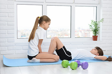 Image showing Two girls perform sports exercises at home during self-isolation