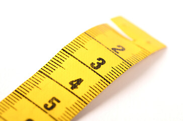 Image showing Close-up of a yellow measuring tape isolated on white - 3