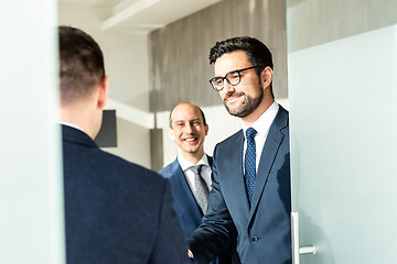 Image showing Group of confident business people greeting with a handshake at business meeting in modern office or closing the deal agreement by shaking hands.