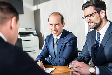 Image showing Team of confident successful business people discussing the contract terms at business meeting in modern corporate office.