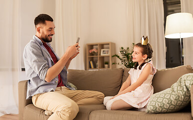 Image showing father photographing daughter by cellphone at home