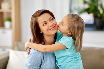 Image showing little daughter hugging her mother on sofa at home