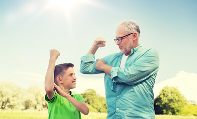 Image showing happy grandfather and grandson showing muscles