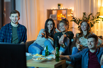 Image showing friends with drinks and snacks watching tv at home