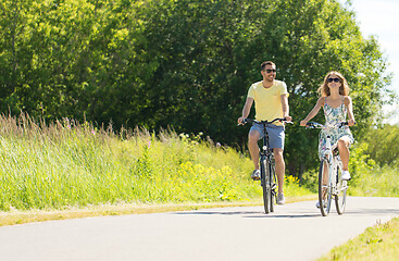 Image showing happy young couple riding bicycles in summer