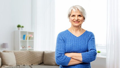 Image showing smiling senior woman in blue sweater at home