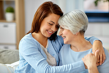 Image showing senior mother with adult daughter hugging at home