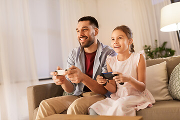 Image showing father and daughter playing video game at home