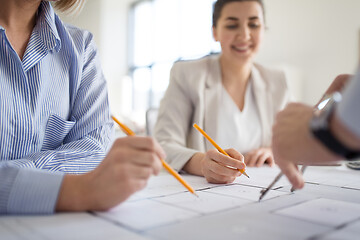 Image showing close up of architects with blueprint at office