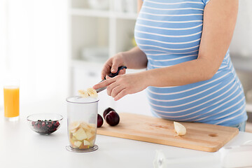 Image showing pregnant woman chopping fruits at home kitchen