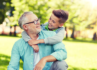 Image showing grandfather and grandson hugging at summer park