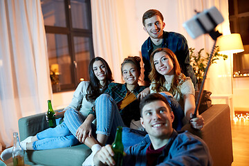 Image showing friends taking picture by selfie stick at home