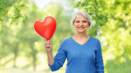 Image showing smiling senior woman with red heart shaped balloon