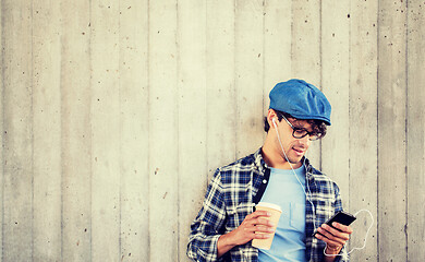 Image showing man with earphones and smartphone drinking coffee