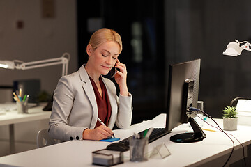 Image showing businesswoman calling on sartphone at night office