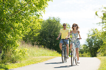 Image showing happy young couple riding bicycles in summer