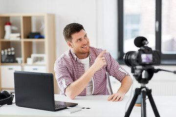 Image showing male blogger with camera videoblogging at home