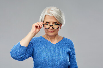 Image showing portrait of senior woman looking above glasses