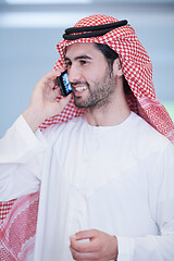 Image showing young arabian businessman using smartphone at home