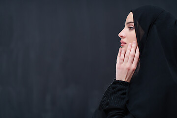 Image showing muslim woman making traditional prayer to God in front of black 