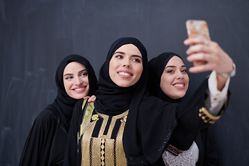 Image showing muslim women taking selfie picture in front of black chalkboard