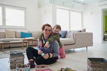 Image showing Mother and little girl daughter playing with jewelry  at home