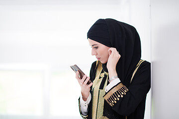 Image showing young modern muslim business woman using smartphone at home