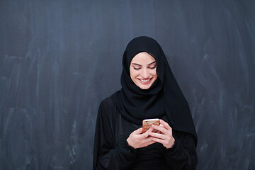 Image showing young modern muslim business woman using smartphone