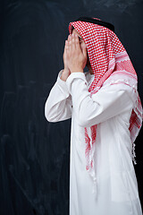 Image showing arabian man making traditional prayer to God, keeps hands in pra