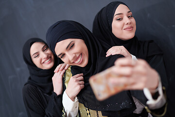 Image showing muslim women taking selfie picture in front of black chalkboard