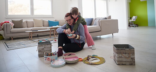 Image showing Mother and little girl daughter playing with jewelry  at home