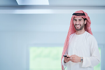 Image showing young arabian businessman using smartphone at home