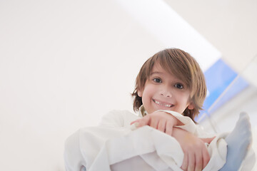 Image showing portrait of little arabian boy sitting on the glass floor