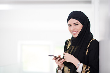 Image showing young modern muslim business woman using smartphone at home