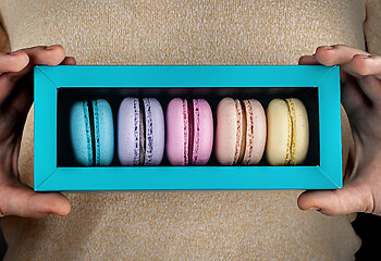 Image showing Closeup macaroons in gift box in hands
