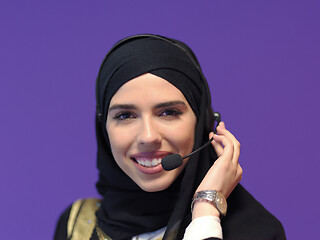 Image showing portrait of muslim woman with headset on purple background