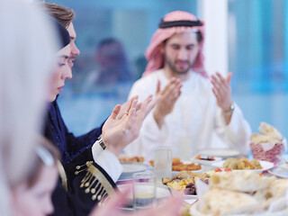 Image showing traditional muslim family praying before iftar dinner