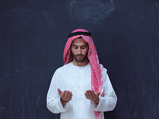 Image showing arabian man making traditional prayer to God, keeps hands in pra