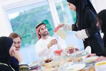 Image showing Muslim family having Iftar dinner drinking water to break feast