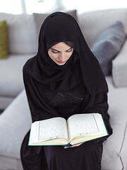 Image showing young muslim woman reading Quran at home