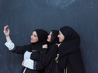 Image showing muslim women taking selfie picture in front of black chalkboard