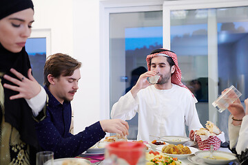 Image showing Muslim family having Iftar dinner drinking water to break feast