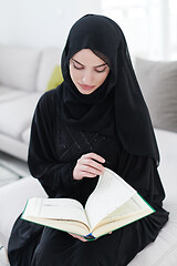 Image showing young muslim woman reading Quran at home