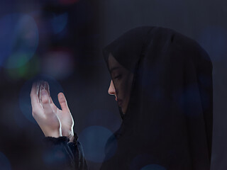 Image showing muslim woman making traditional prayer to God in front of black 