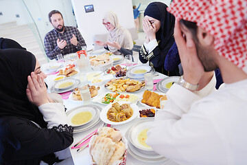 Image showing traditional muslim family praying before iftar dinner