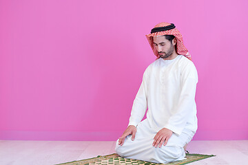 Image showing young arabian muslim man praying on the floor at home